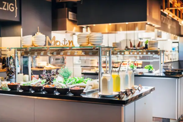 Counter with salads and jars filled with various dressings.