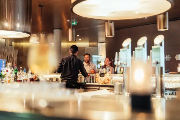 A group of people are standing at a bar.
