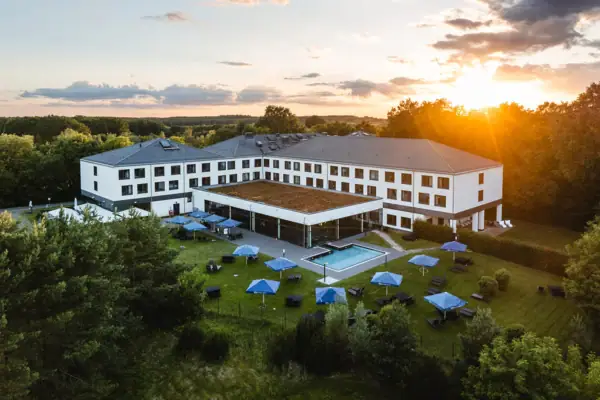 Building with a pool and parasols in the centre.
