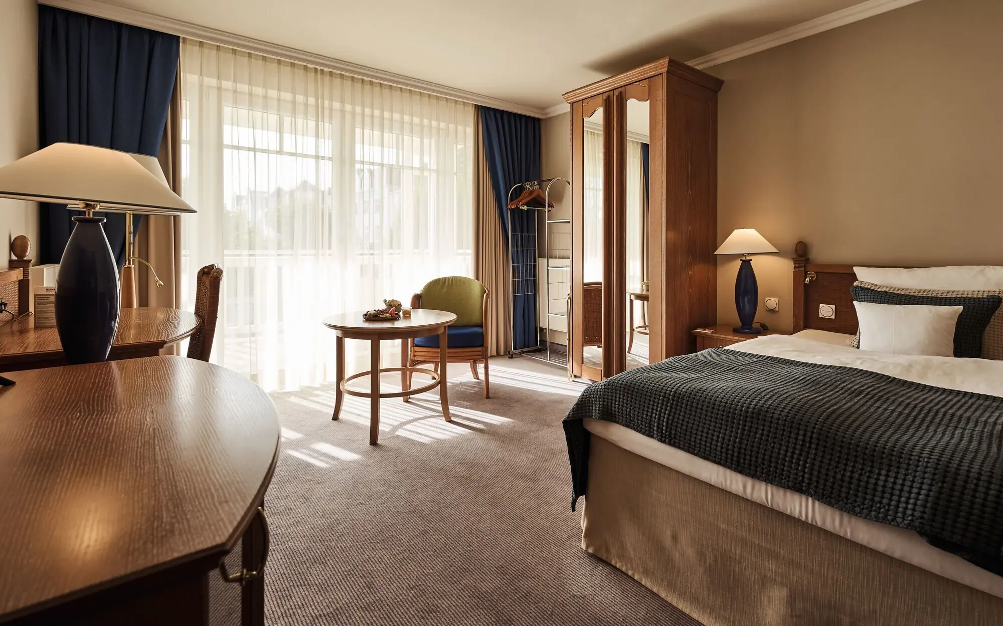 Interior view of a bedroom featuring a bed with linens and a bedside table.