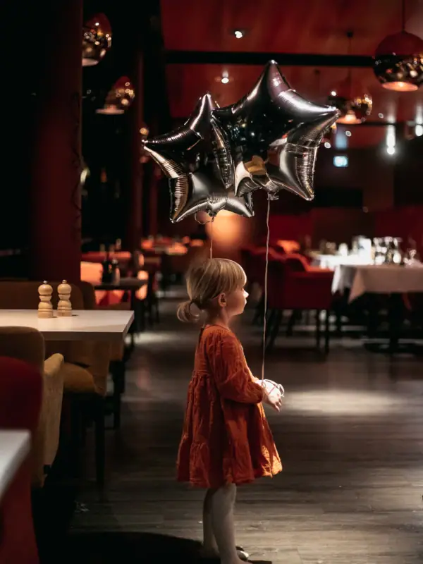 A child is holding a star-shaped balloon.
