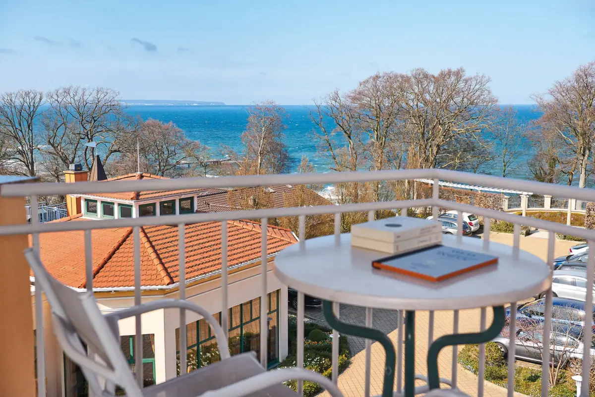 A table with a book on it and a view of the sea.