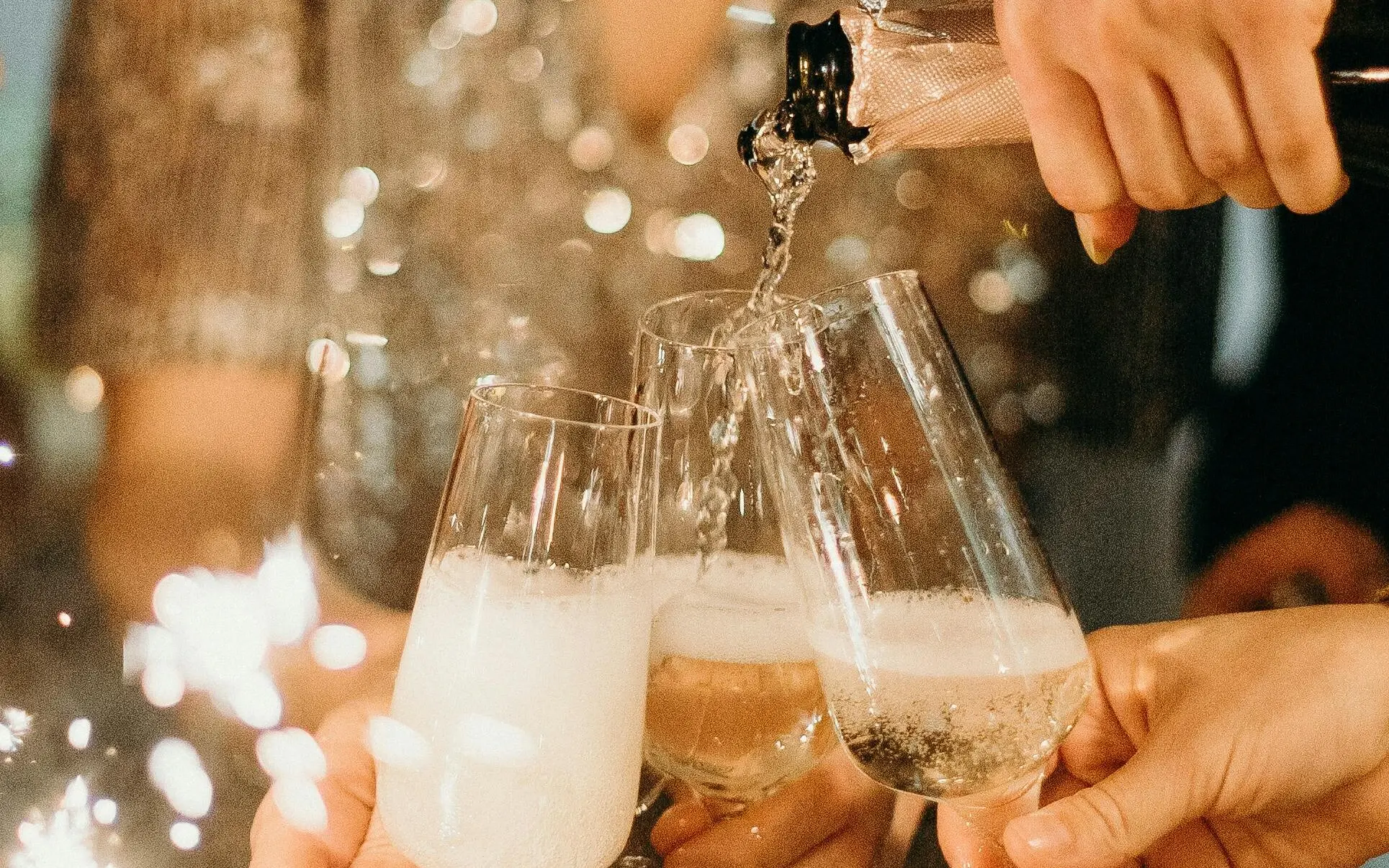 Group of people holding champagne glasses in an interior.