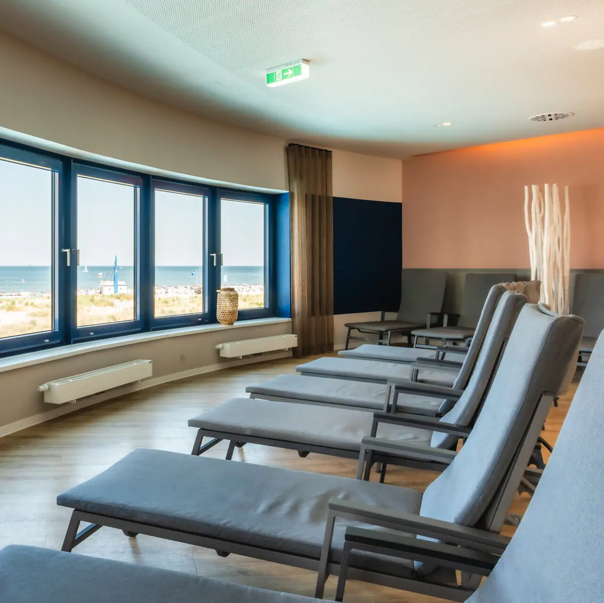 A room with chairs and windows, featuring a modern interior design. With a view of the Baltic Sea.