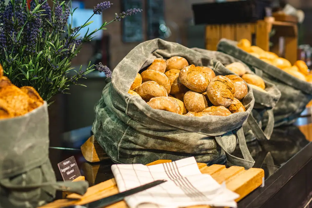 A group of loaves of bread in bags on a counter.
