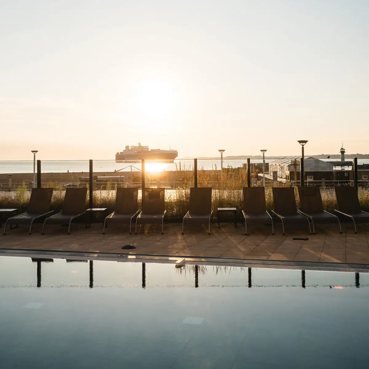A row of sunbeds by the outdoor pool.