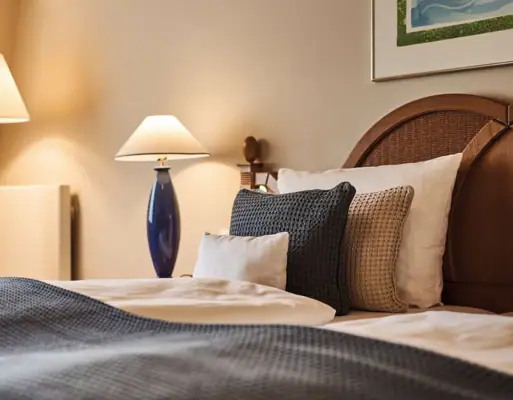 A bed with pillows and a lamp.