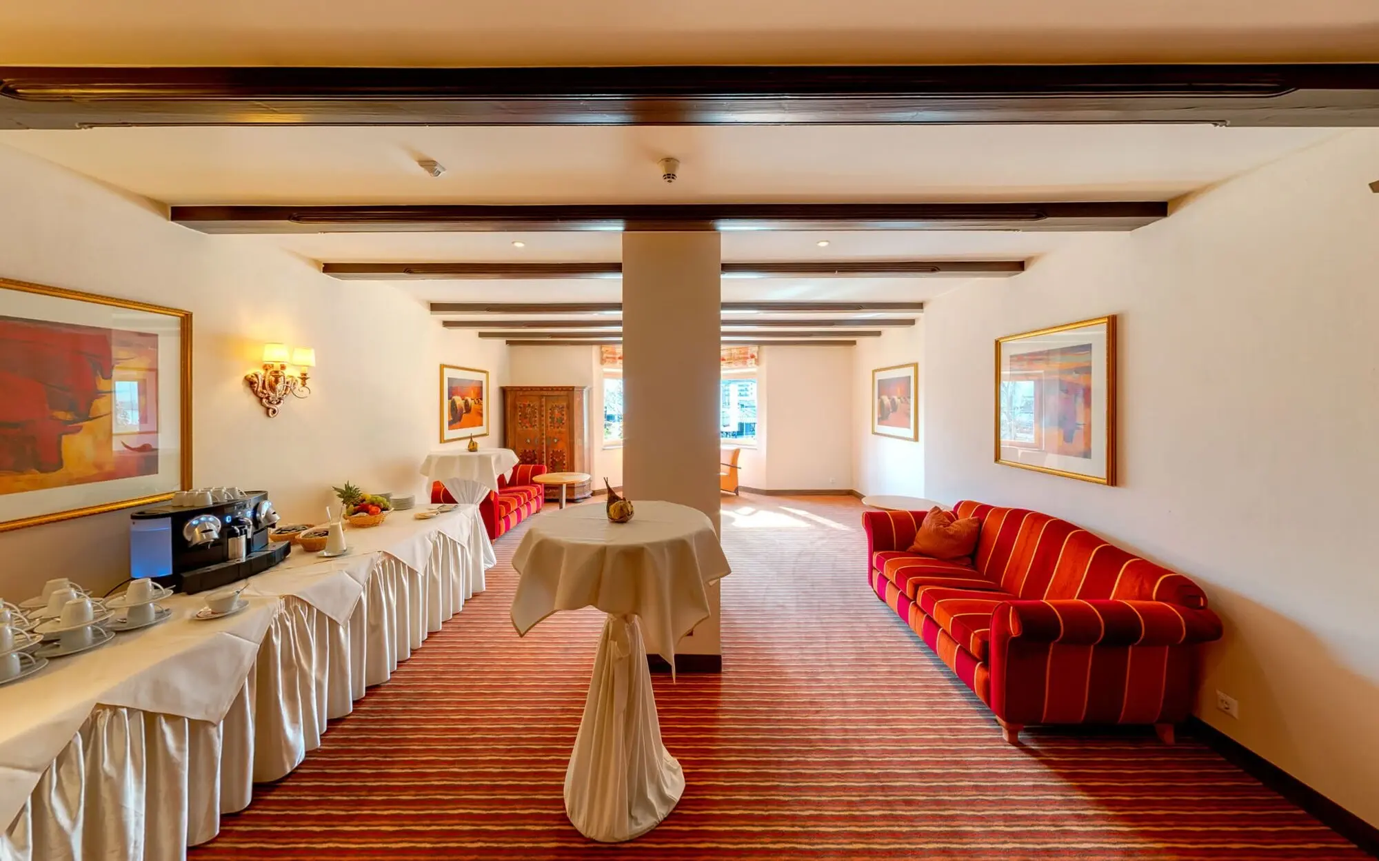 Interior with tables and chairs, decorated with vases and tablecloths.