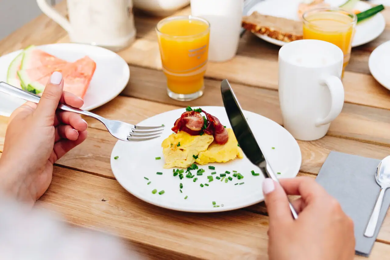 Scrambled eggs One person eats a meal at a table.