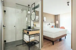 Double room A bathroom with a glass shower and a bed.