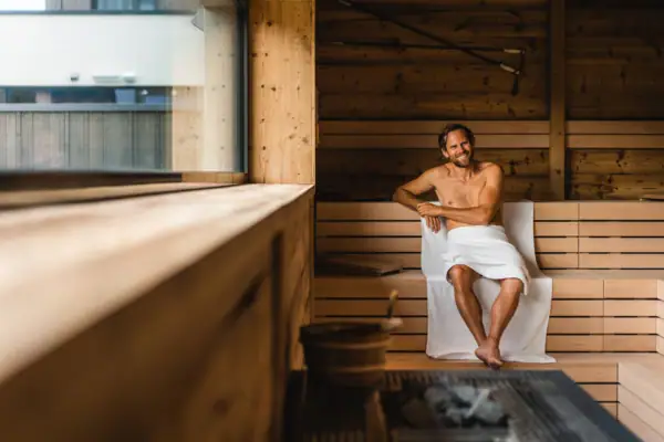 A man sits in a sauna.
