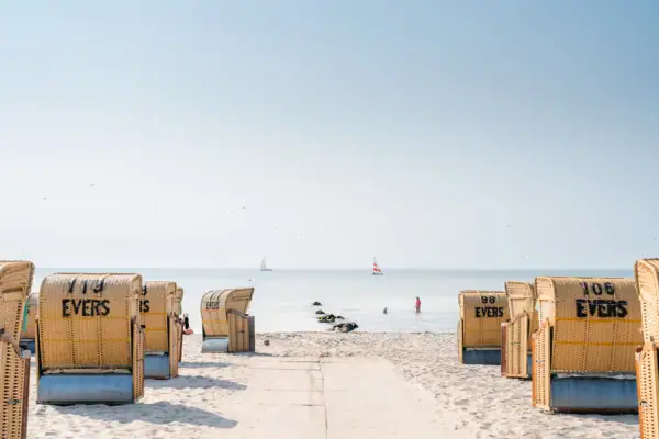 Beach with many beach chairs and a body of water in the background.
