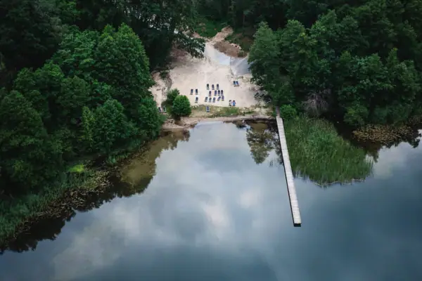 A body of water with a jetty and trees.