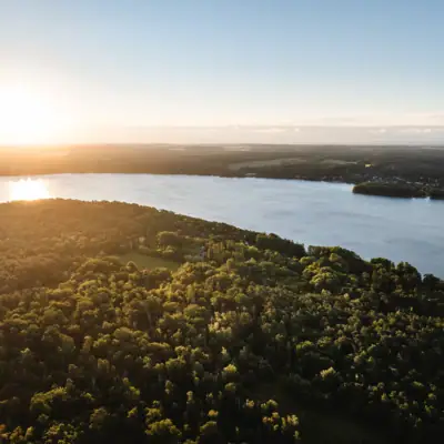 A body of water with trees and a town in the distance.