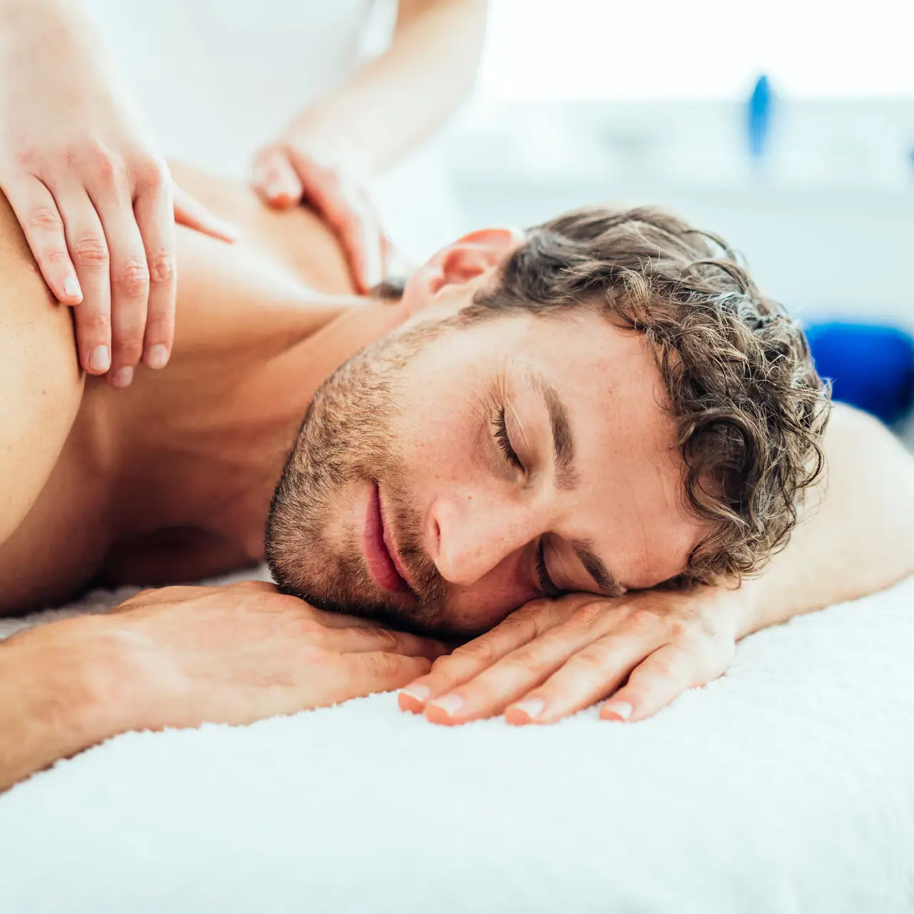 Massage A man is lying on a massage table.