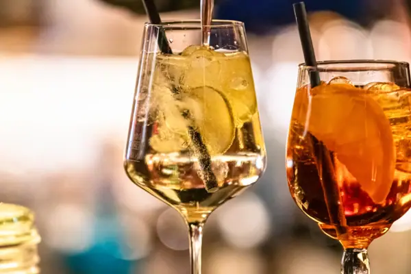A person is pouring a drink into a glass.