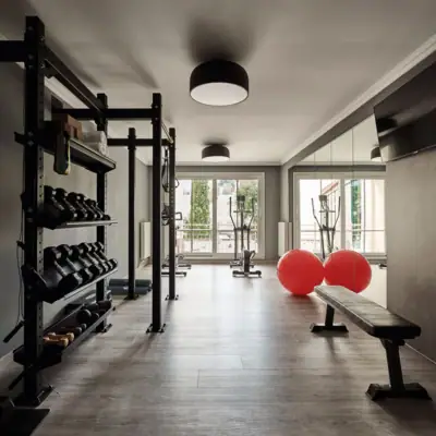 A gym with dumbbells and a bench.