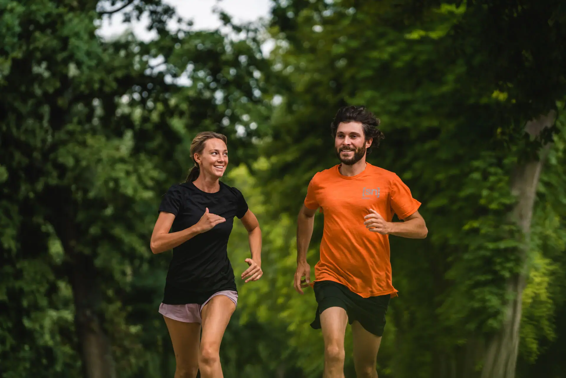 Jogging A man and a woman walk along a tree-lined path.