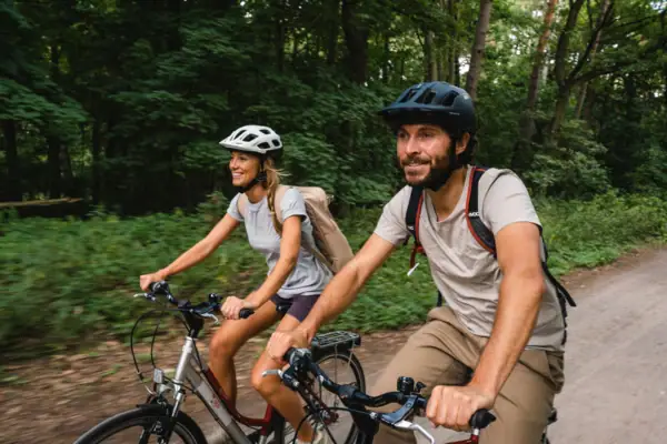 Activities A man and a woman are cycling in the forest.