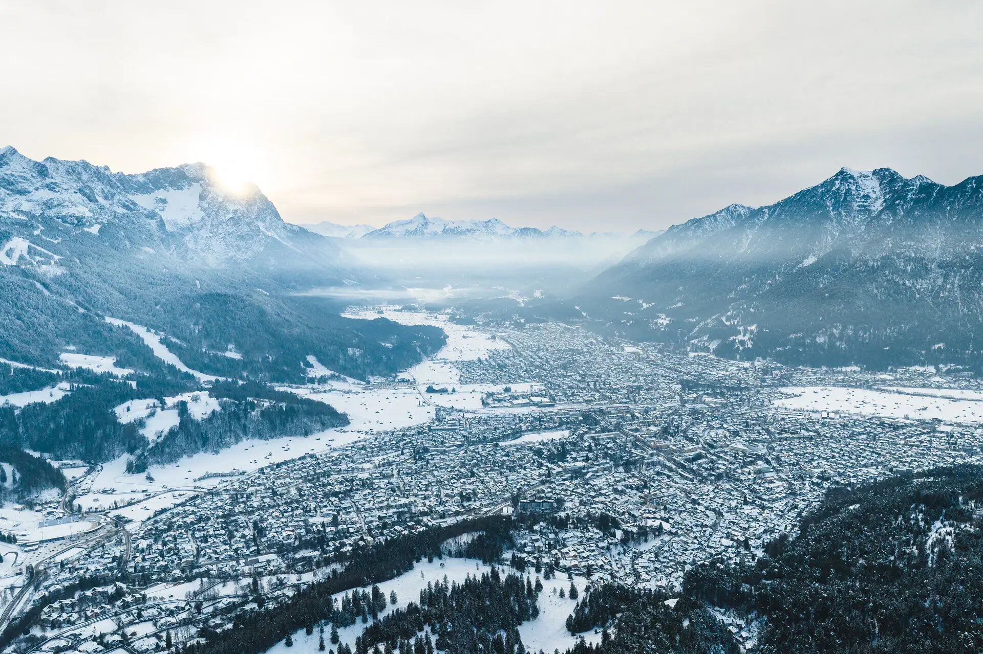 Arrival by plane Snow-covered city with mountain landscape in the background.