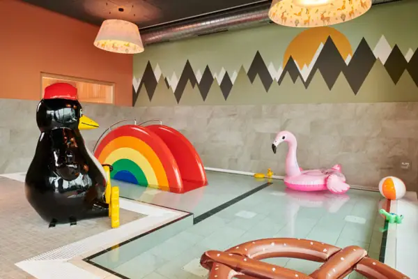 A pool with inflatable toys and a penguin.