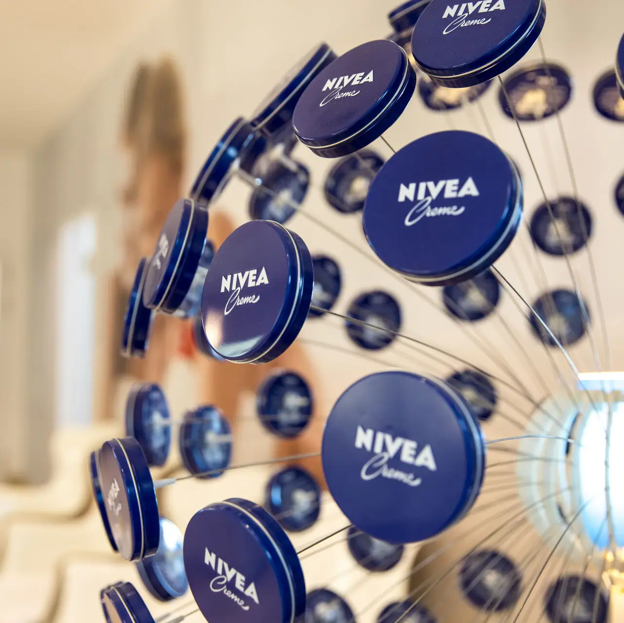 A group of blue cans of NIVEA on a wire.