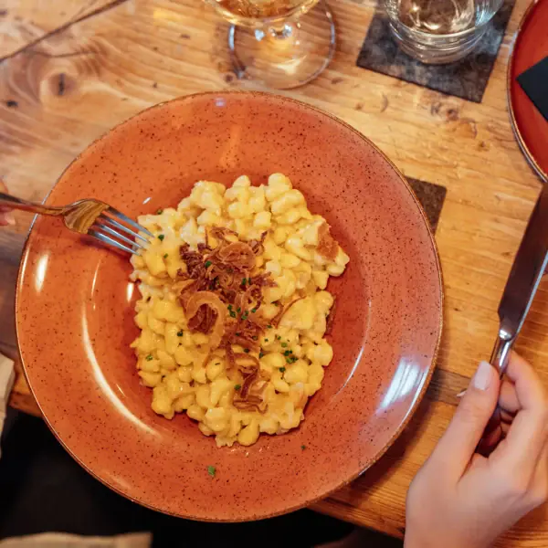 A plate of macaroni and cheese, with a fork and a knife beside it.