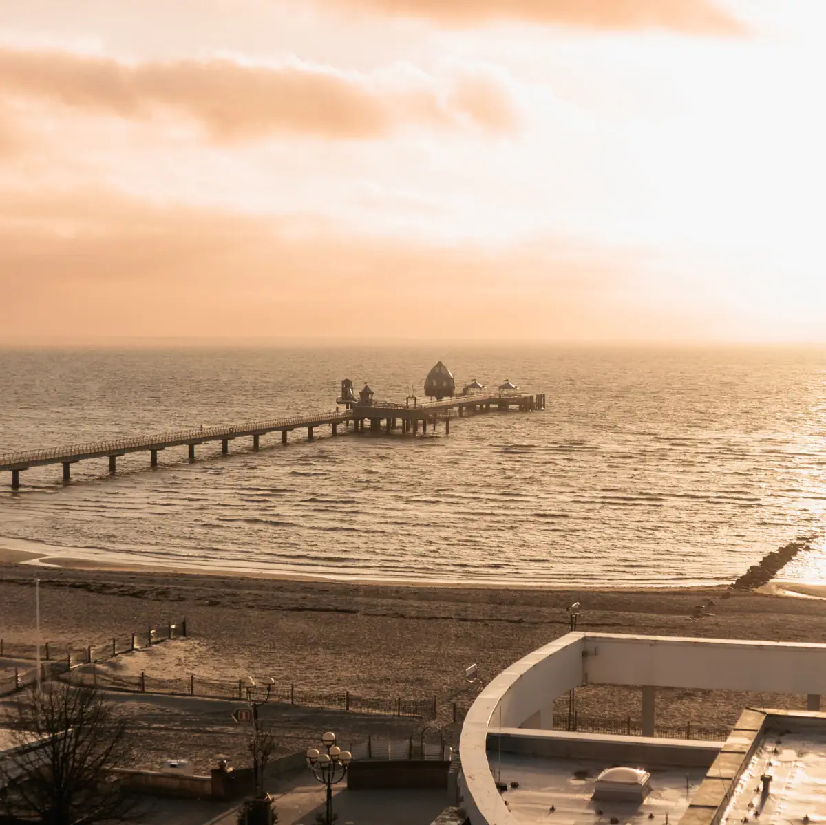 A long jetty in the water beneath a cloudy sky.