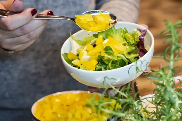 One person fills bowls with food.