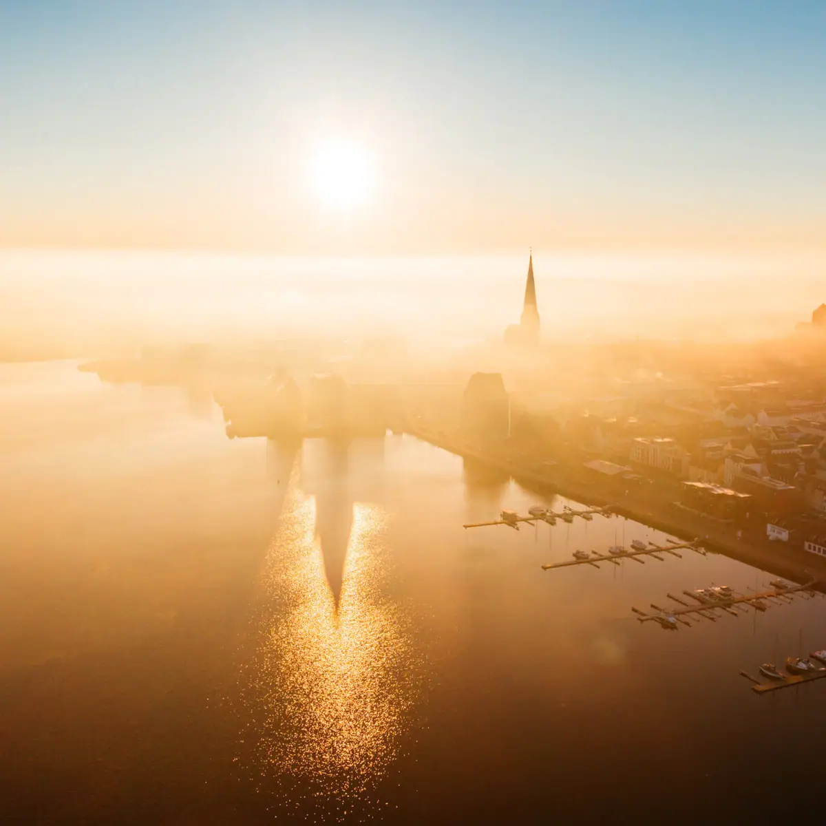 An aerial view of Rostock and the neighbouring waterfront as the sun rises.