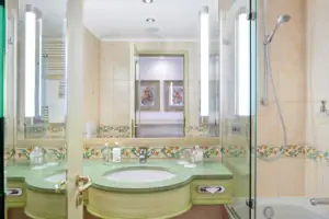 Junior suite facing the lake with balcony Bathroom with green washbasin and glass shower