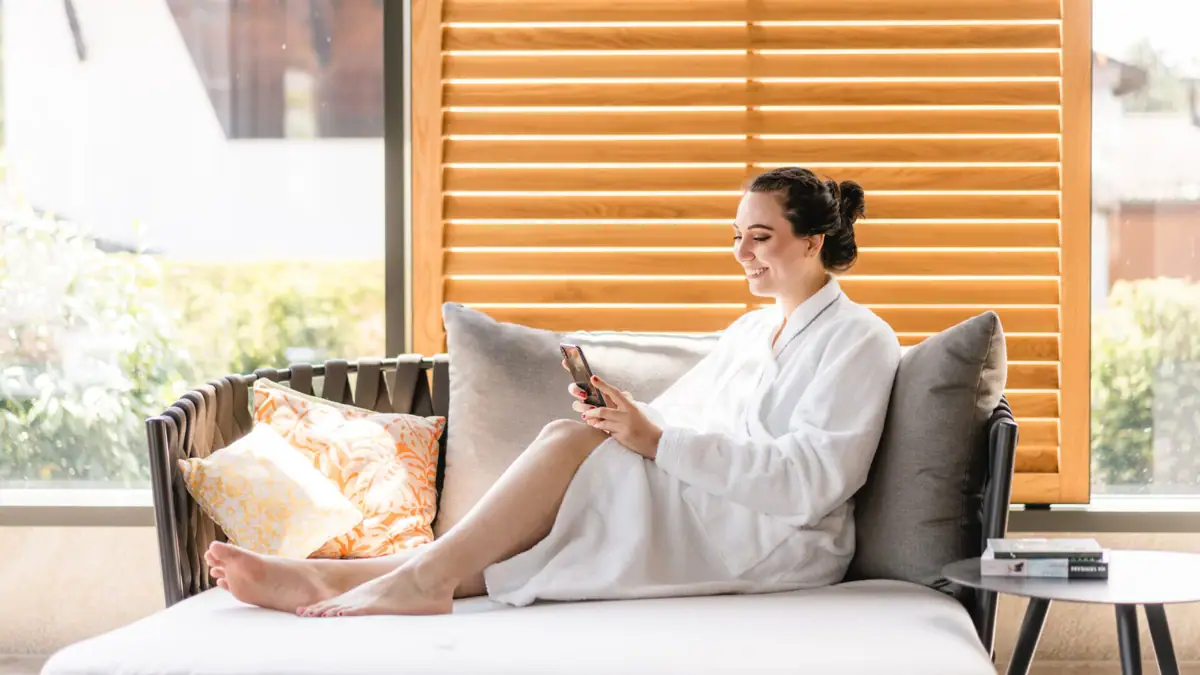 Day SPA A woman in a bathrobe sits on a sofa.