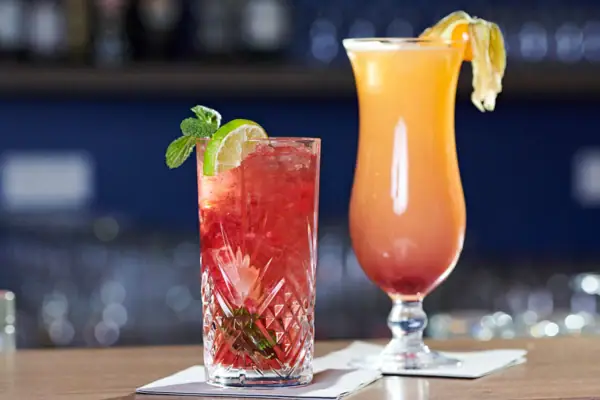 Two cocktails on a bar.