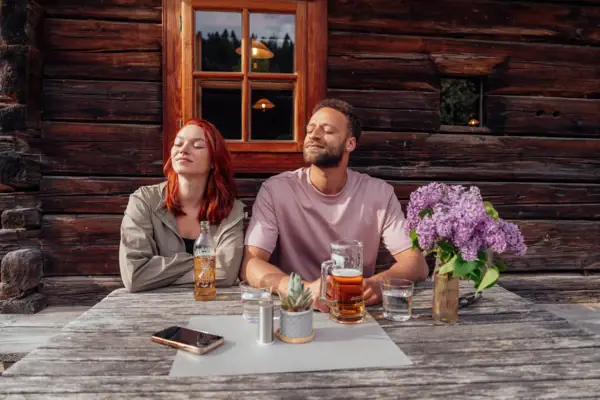 A man and a woman are sitting at a table with some drinks.