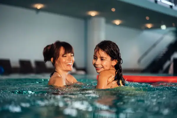 A woman and a girl in the swimming pool.