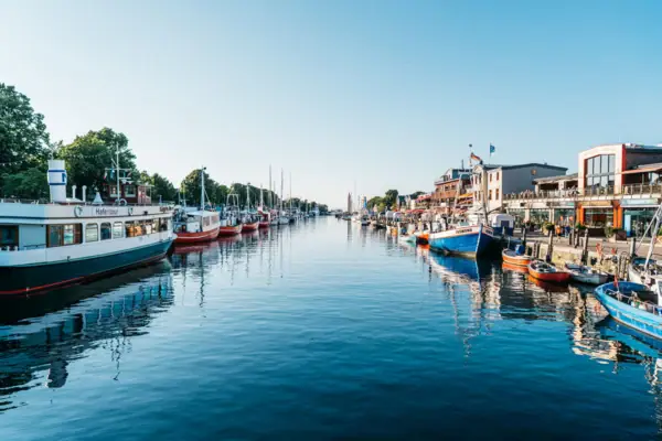 Waterway with boats and buildings, Naples in the background.