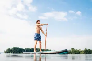Ein Mann auf einem Stand-Up-Paddle-Board auf einem See.