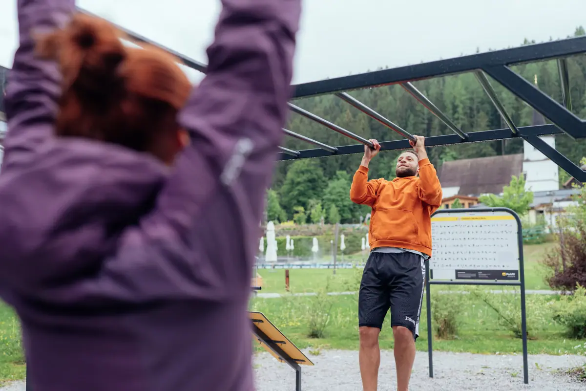A man is holding on to some climbing bars.