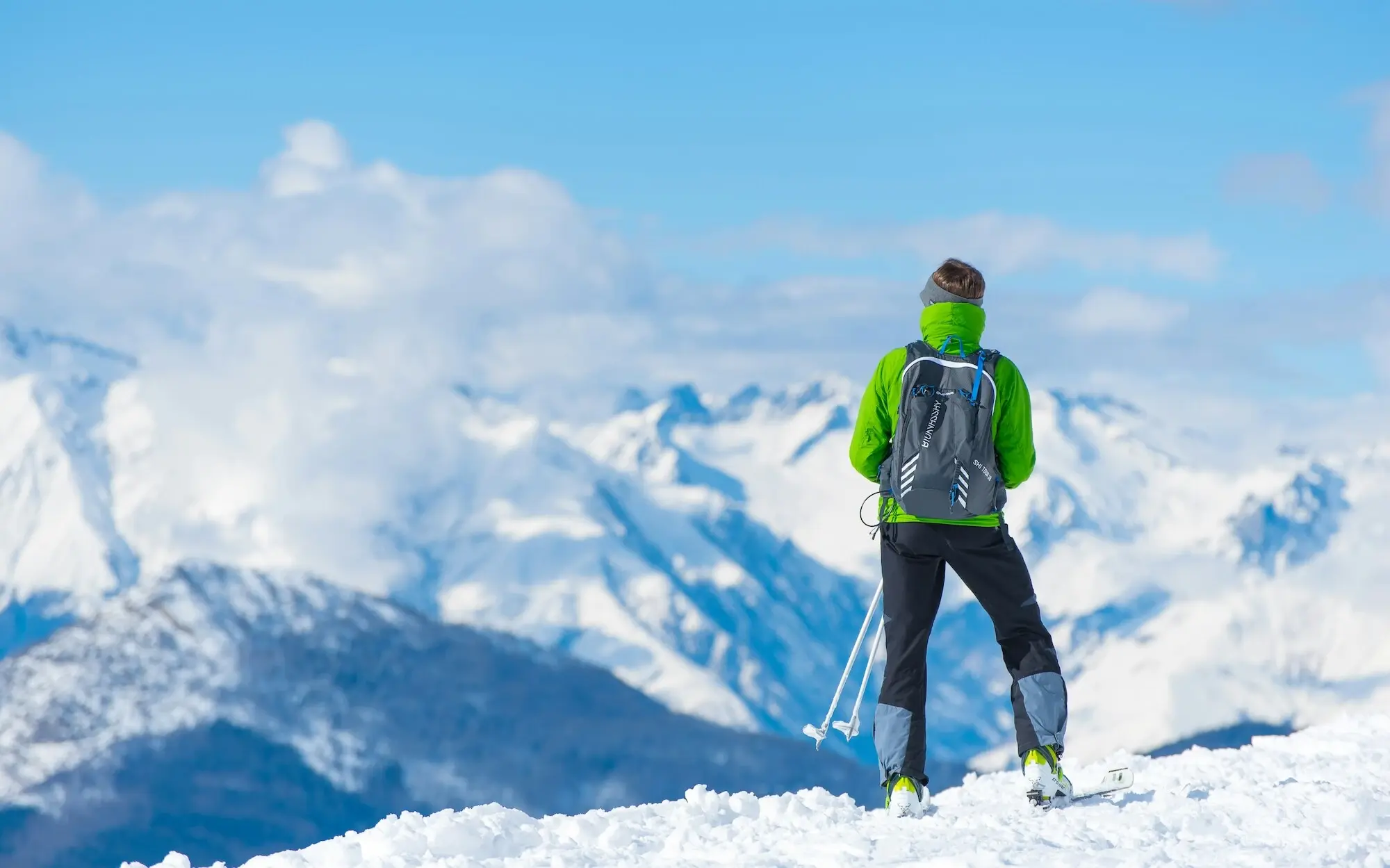 Skier looks at mountains in winter.