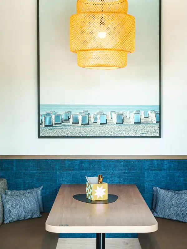 Bar at the aja Warnemünde A table with a ceiling lamp.