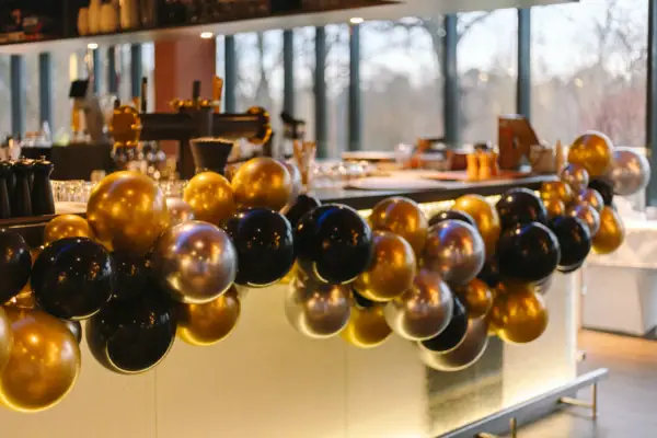 Balloon garland made of gold and black balloons attached to the counter