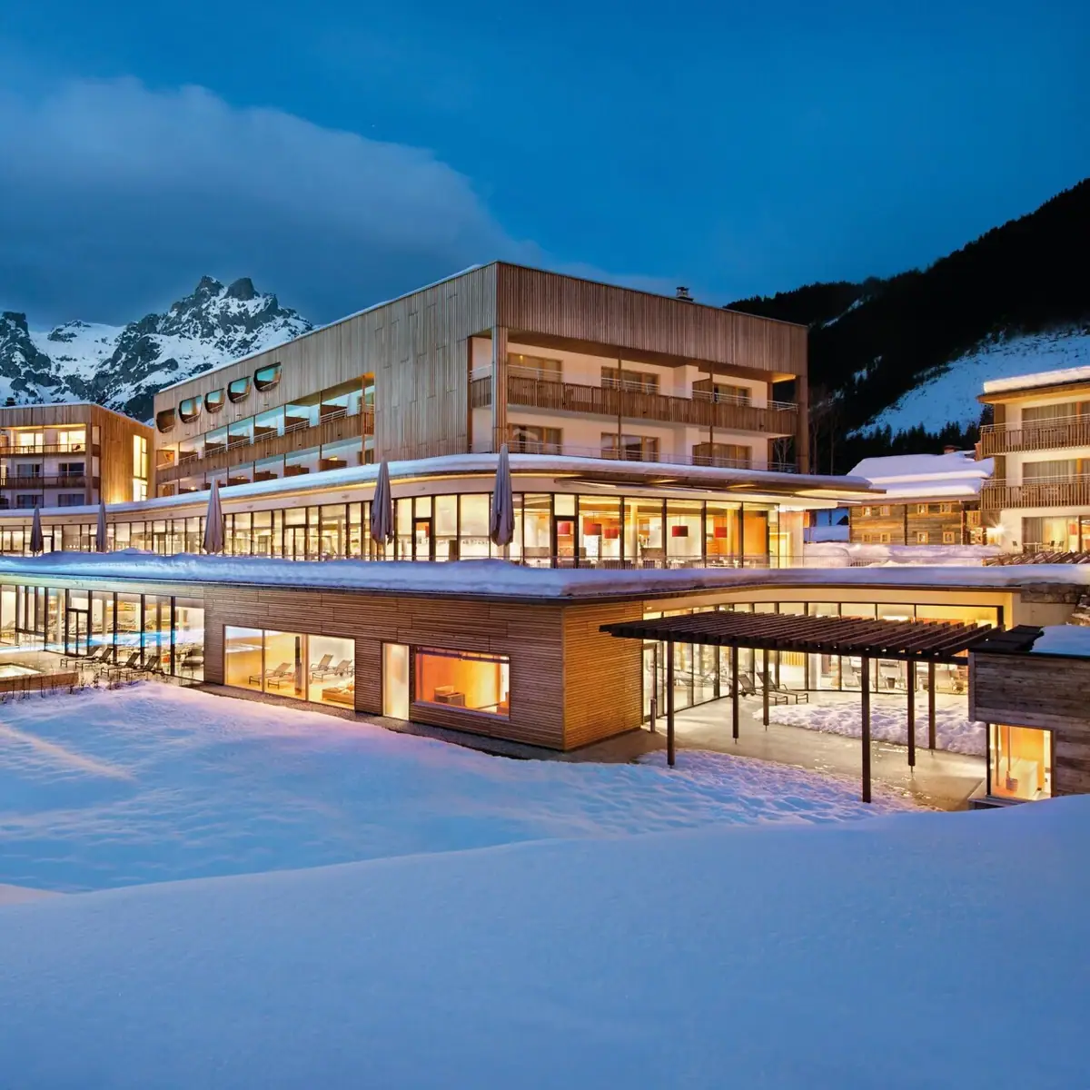 An illuminated building on snow-covered ground.