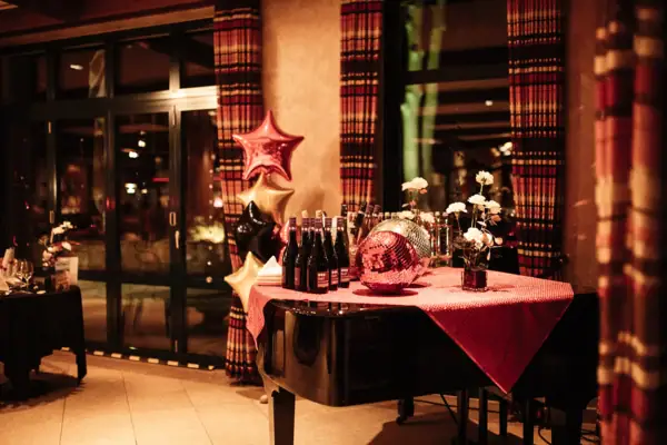 New Year's Eve decoration A table with a piano and bottles of wine.