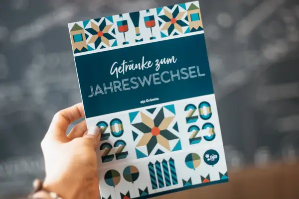 Hand holds a programme booklet with handwritten notes.