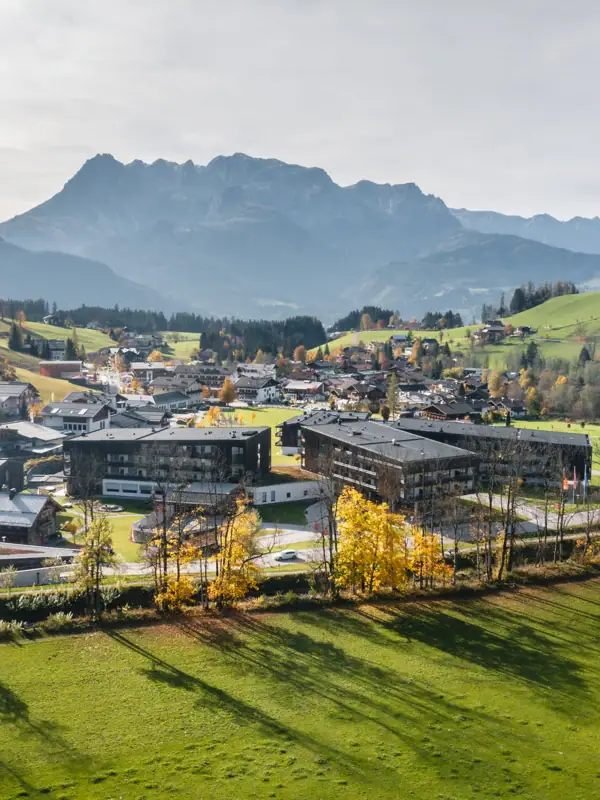The village with the hotel complex in a valley with mountains in the background.