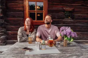 A man and a woman are sitting at a table with some drinks.