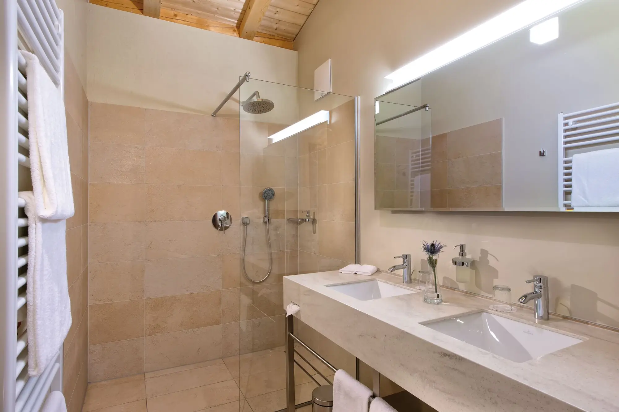 Interior view of a bathroom with shower and washbasin, equipped with fittings and bathroom accessories.