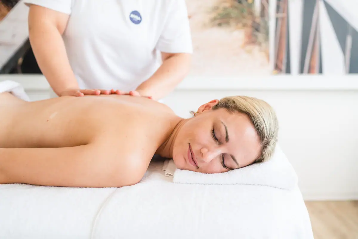 A woman lies relaxed on a massage table.