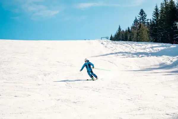 A person skis down a snowy slope.