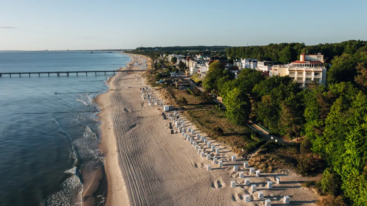aja Strandhotel Bansin Beach with buildings and trees in the foreground.